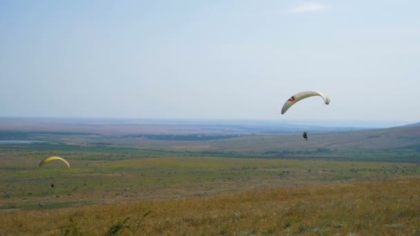 Extrém siklóernyős repülés ellen tiszta kék ég, Napsugár ragyog a kamera. Paraglide repülés tapasztalat ejtőernyőzik nyár. — Stock videók