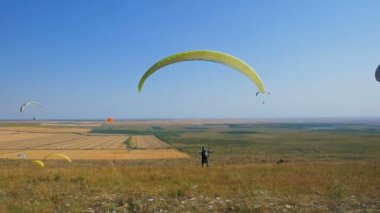 Birçok yamaç paraşütçüsi uçuyor. Siluet insanlar Yamaç paraşütü. Yamaç paraşütle uçuş deneyimi skydive yaz.