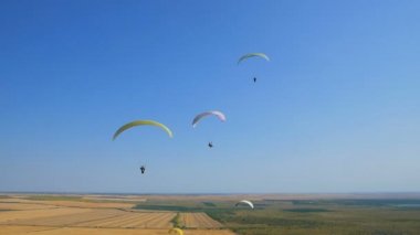 Birçok yamaç paraşütçüsi uçuyor. Siluet insanlar Yamaç paraşütü. Yamaç paraşütle uçuş deneyimi skydive yaz.