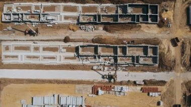Konut binalarının inşaatı. Yükseklikten inşaat alanı. Hava manzaralı inşaat alanı. Özel ekipman işi. İnşaat alanının havadan görüntüsü. Binaların havadan görünüşü.
