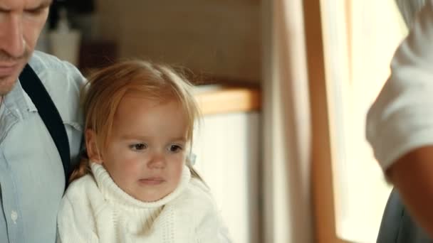 A little girl is sitting on her fathers lap. Family portrait. Happy family spending time together at home. — Stock Video