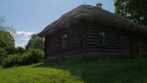 La vieille maison en bois dans le village habitée par des personnes âgées et la cour a été envahie par l'herbe et le toit de chaume est fuyant — Video