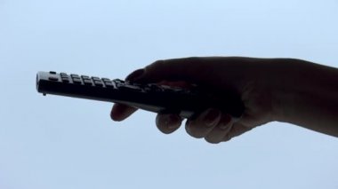 Kadın el beyaz arka plan üzerinde izole bir tv uzaktan kumanda işletim