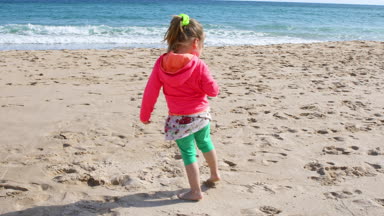 dört yaşında seyir için toplama ve deniz kabukları anne ya da bebek bakıcısı Bolonia Beach, Cadiz, Endülüs, İspanya, Avrupa'nın yanında Kum Plajı sahilinde toplama kız.