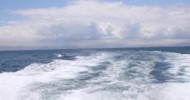 Motorlu tekne iz okyanus su veya uyku modundan çıkarma, köpük ve dalgalar halinde Cebelitarık Boğazı, Cadiz, İspanya, Avrupa ve bulutlu gökyüzü ile arazi ufuk arkasında