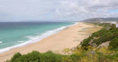 altın kum ile göksel Zahara de los Atunes Beach, yüksek görünüm manzara, Tarifa, Cadiz, Endülüs, İspanya yeşil turkuaz okyanus su ve ufuk bulutlu gökyüzü mavi