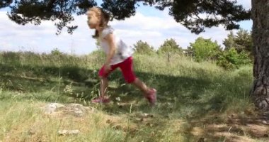 Dört yıl yaşlı sarışın kız bir sopayla çömelmiş kalkıyor ve annesi şehir dışında doğru yürür. 4k video