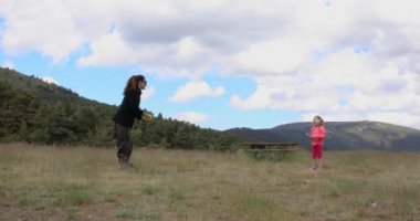 Kadın ve dört yıl yaşlı sarışın kız Guadarrama, Madrid, İspanya, Europe yakın kırsal kesimde top oynamaktan. 4k video. 