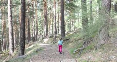 4k video: bir dört yaşında sarışın kız komik izi doğa yürüyüş günü yaklaşıyor, o bakar ve hoşnutsuzluğunu konuşmak