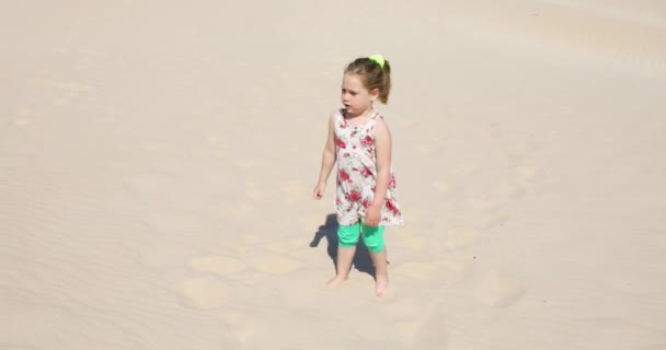四岁的金发女孩穿着衣服走在沙丘上 并与她的母亲在加斯 安大路西亚 西班牙的背包交谈 — 图库视频影像