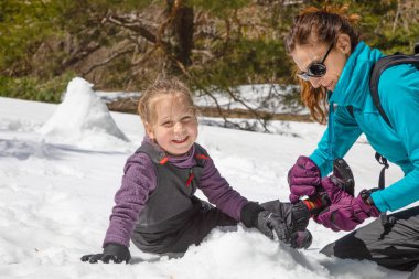 komik kızı arıyorum, doğada kar üzerinde oturan dört yaşında sarışın kız için önyükleme yerleştirerek kadın