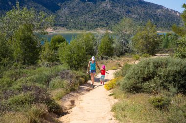 yolu ile küçük kız dört yaşında ve yaz Buendia (Guadalajara, İspanya, Avrupa'nın rezervuarı yanındaki kırsalında hiking kadın)