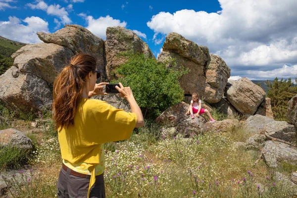 スマート フォンで写真やビデオ録画をして彼女の娘 歳の女の子 Navafria グアダラマ自然公園 マドリード スペイン ヨーロッパで岩の上に座って女性 — ストック写真