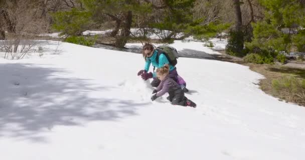 幸福的家庭四岁的金发孩子和女人的母亲 坐在膝盖上玩着摸雪 使雪人在冬季的山上 — 图库视频影像