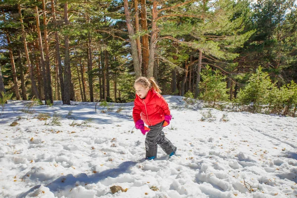 Joyeuse petite fille marchant sur la neige en montagne — Photo