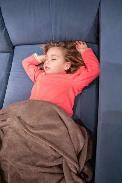 Little kid lying on sofa sleeping with arms up — Stock Photo, Image