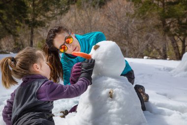 kız ve anne natur bir kardan adam yapma