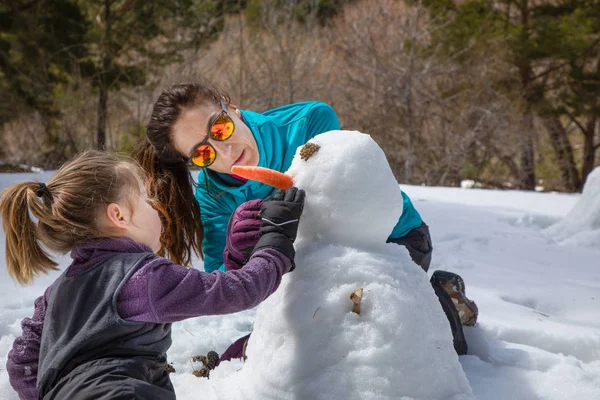 kız ve anne natur bir kardan adam yapma