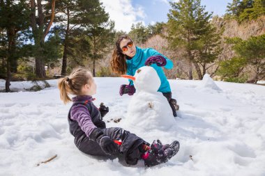 doğada bir kardan adam yapma anne ve küçük kız