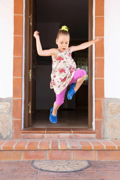 Velký skok malé dívky, skákající ze dveří — Stock fotografie