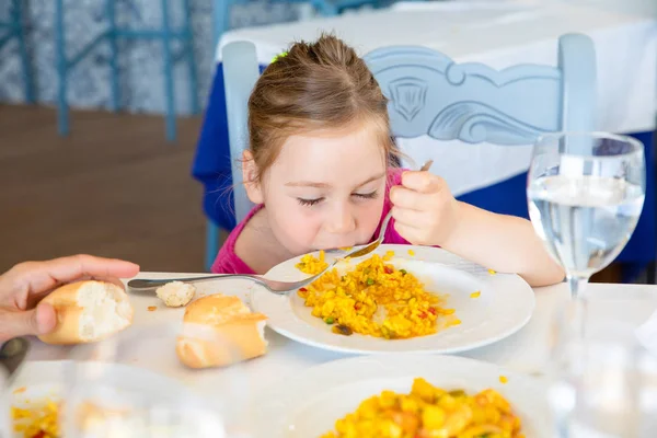 Lustiges kleines Mädchen isst Paella aus Gericht — Stockfoto