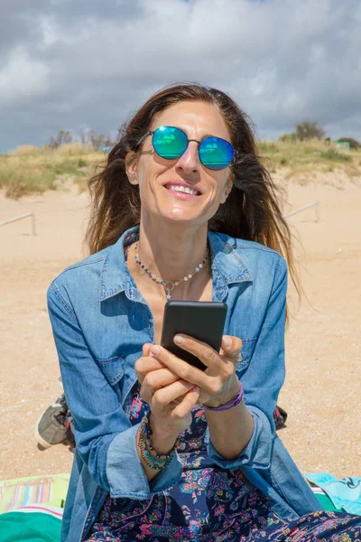 Πορτρέτο της χαμογελαστή γυναίκα με το κινητό τηλέφωνο στα χέρια — Φωτογραφία Αρχείου