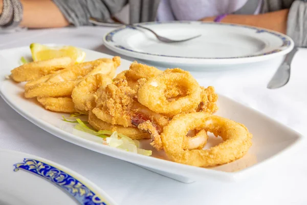 Close up de bandeja branca com anéis fritos de lula no restaurante — Fotografia de Stock