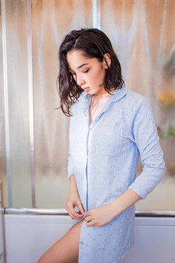 Güzel esmer kadın takılır gömlek düğmeleri, banyo zamanı. Sonra ev yapımı giysi duşta kız Giydir