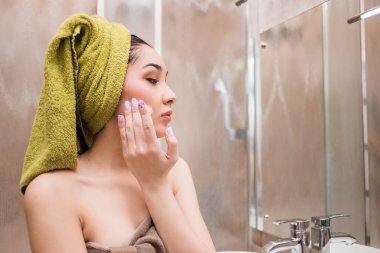 Duş uyguladıktan sonra yüz nemlendirici güzel bir kadın. Spa, bakım kavramı