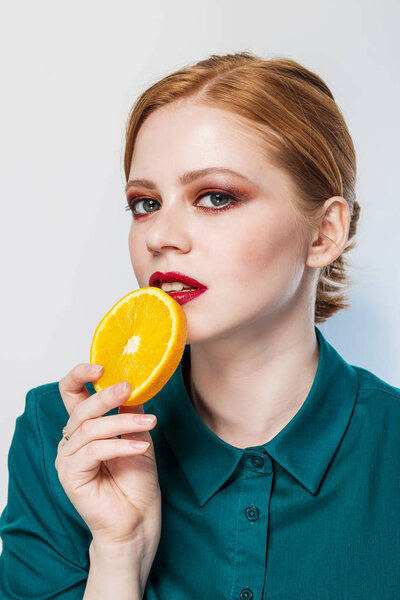 young beautiful woman with citrus orange fruit having. eating orange. Health, youth, clean skin, makeup concepts