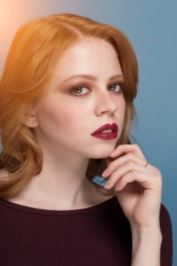 Dalgın Kızıl saçlı kız tarafına, portre mavi arka plan üzerinde Kapat.