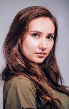 Gri arka plan üzerinde güzel şirin esmer kadın portresi kapatın. Olumlu duygular, yüz ifadesi. Seksi kız