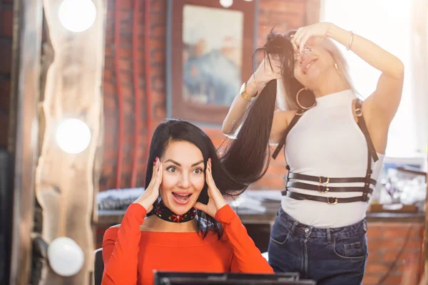 Female hairdresser with scissors makes a haircut for a woman in beauty salon. Beauty studio
