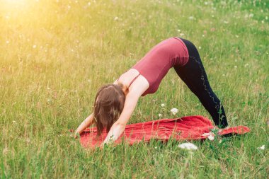 Genç ince kız yeşil çim zemin üzerine açık havada egzersizleri yapıyor. Yoga, spor, sağlık kavramlar