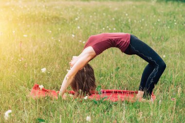 Genç kız egzersiz yaparak ince köprü park içine açık. Yoga, spor, sağlık kavramlar