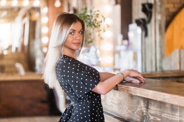 müşteriler resepsiyonda bekleyen kameraya gülümseme ile güzel seksi sarışın kadın arıyor.