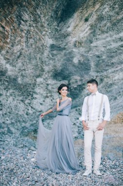 Bir gülümseme ile arıyorsunuz birbirlerine, sarılmak, düğün günü kayalar, yakınındaki güzel çift