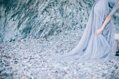 Odağı güzel taşlar, kayalar üzerinde sahil, resmi kenarıyla elbiseli disfocus kız