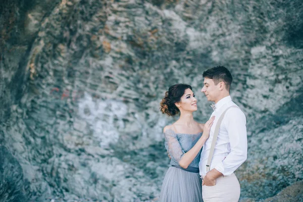 美丽的情侣靠近岩石 看着彼此的微笑 婚礼的日子 — 图库照片