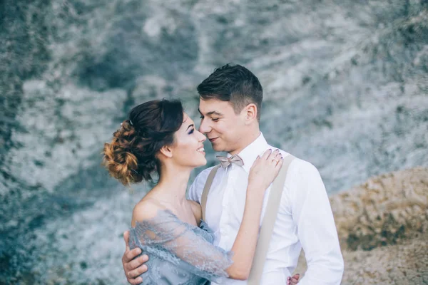 美しいカップルの新郎新婦の結婚式の日を抱いて 互いに笑顔で探して岩近きます ライフ スタイル 家族の概念 — ストック写真