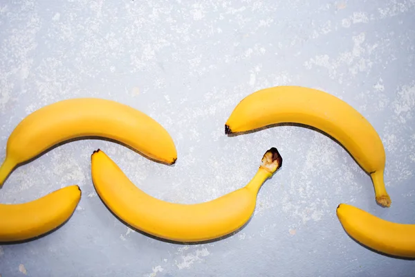 Bananas on a grey textured background with with copy space, top view