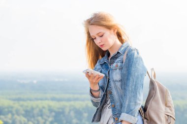 Genç güzel sarışın kadın smartphone dağlardaki kullanır. Seyahat, Internet, iletişim, teknoloji kavramları