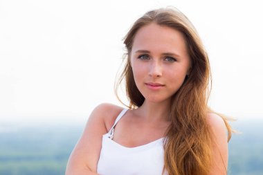 Kameraya doğa arka plan üzerinde seyir yüzünde çiller ile güzel bir kadın portresi kapatın. Doğal güzellik, gençlik kavramı