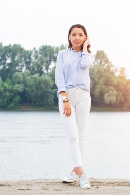 Tam yükseklikte riverfront güzel esmer kadın portresi. Kameraya bakarak gülümseyen kız