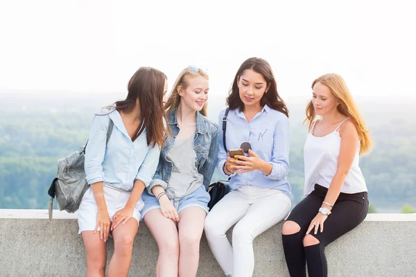 Cztery Piękne Kobiety Siedzą Parku Spojrzeć Smartphone Uśmiech Nowoczesna Technologia — Zdjęcie stockowe