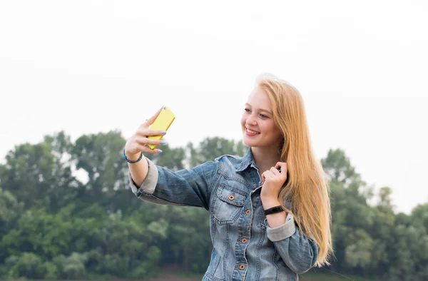 笑顔と自然の背景に Selfie を取ってかなり若いブロンドの女性 — ストック写真