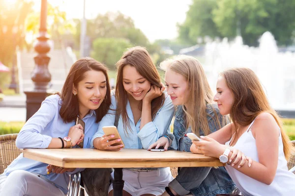 Cuatro Mujeres Jóvenes Atractivas Usan Teléfonos Inteligentes Una Mesa Parque — Foto de Stock
