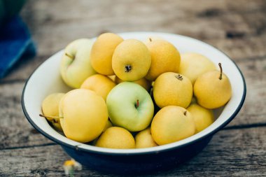 Taze olgun armut ve elma kase doğal zemin üzerine. Seçici odak