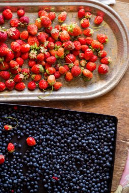 Düz çilek ve yaban mersini vintage ahşap masa üzerinde yatıyordu. Yaz, sağlıklı gıda, vitaminler