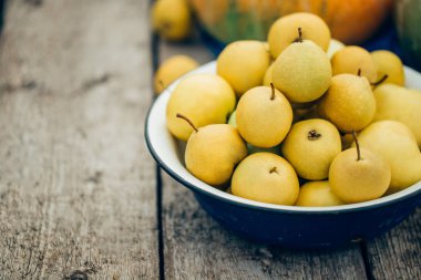 Güzel olgun ev armut ahşap arka plan üzerinde büyük bir kase içinde. Kopya alanı yakın çekim